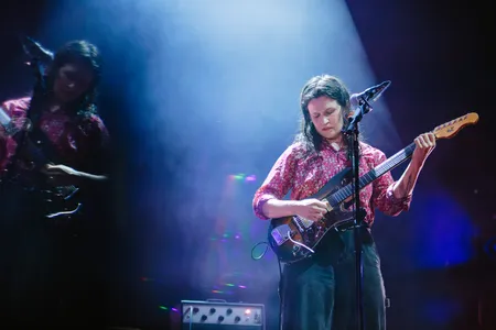 vrouw speelt gitaar op het podium