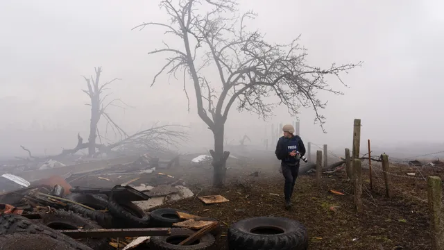 1 - Photographer Evgeniy Maloletka picks his way through the aftermath of a Russian attack in Mariupol, Ukraine, Feb. 24, 2022.