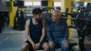 Twee mannen zitten naast elkaar in de sportschool.