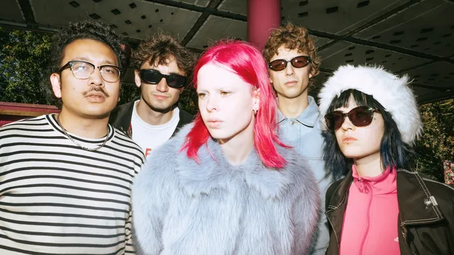 Amsterdamse band POM naast elkaar met zangeres Liza vooraan met roze haar