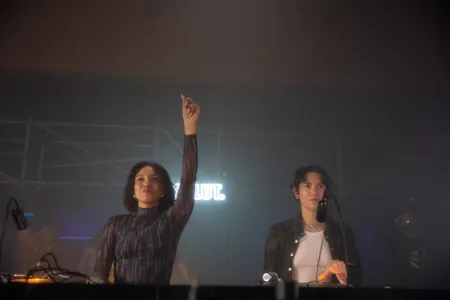 Twee vrouwen in de dj-booth, de ene steekt een vinger omhoog