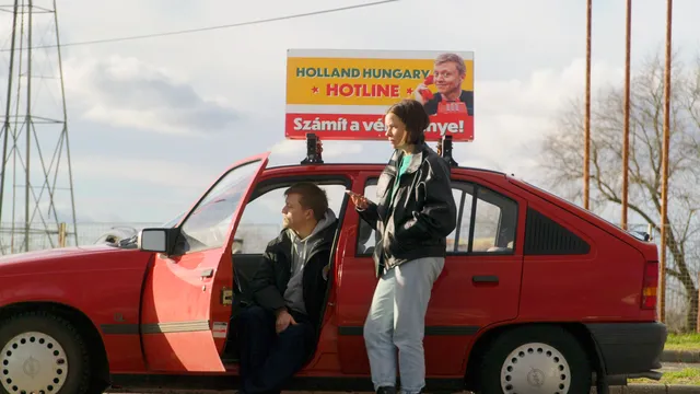 Nicolaas en Noemi bij een rode auto.