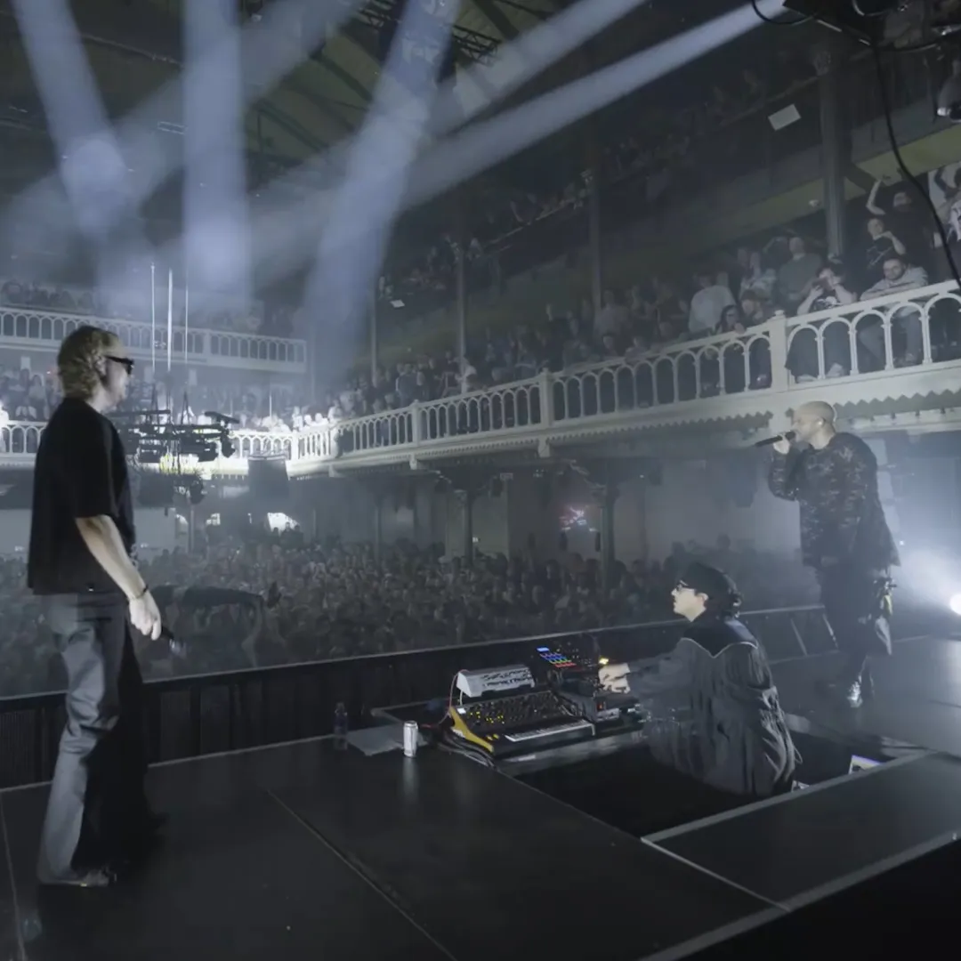 Twee mannen die op het podium van de concertzaal paradiso staan te zingen