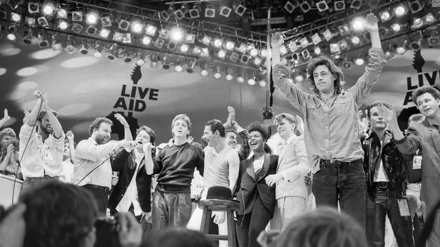 vnlr: George Michael, Harvey Goldsmith, Bono, Paul McCartney, Freddy Mercury, Andrew Ridgley, Helena Springs, David Bowie, Bob Geldof, Adam Ant, Stuart Adamson

Live Aid dual venue benefit concert held on 13th July 1985 at Wembley Stadium in London, England, and the John F. Kennedy Stadium in Philadelphia, Pennsylvania, United States. The concerts were organised as a follow up to the Band Aid single "Do They Know Its Christmas?" to raise money for victims of the famine in Ethiopia. Picture shows the performers on stage for the grand finale of the concert at Wembley.