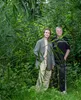 Roos en Barbara staan tussen de groene bladeren. Roos (links) draagt een grijze oversized blazer, Barbara (rechts) een zwart t-shirt.
