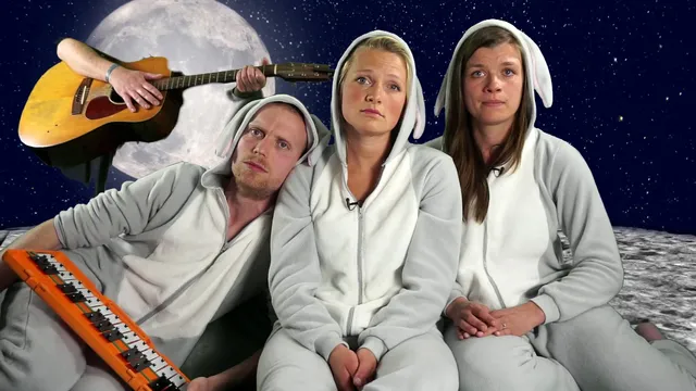 De sekszusjes zitten in een ruimte-decor met een konijnen-onesie aan.