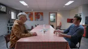 MOB leider Johan Vollenbroek en een pluimveehouder zitten tegenover elkaar aan tafel en hebben een dialoog.