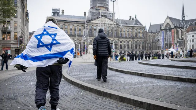 Persoon loopt op de dam met de Israelische vlag omgewikkeld