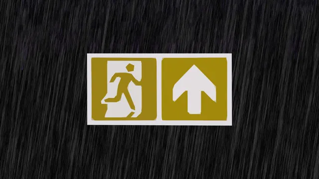 Een nooduitgangbordje met mosterdgele kleur op een zwarte achtergrond met regendruppels