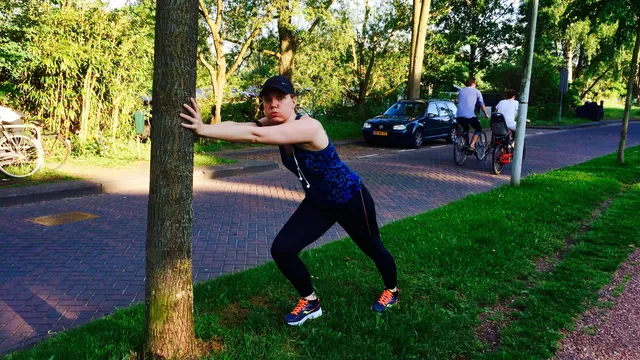 Femke stretchend bij een boom