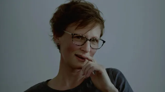 Een van de hoofdpersonen - een vrouw met kort haar - kijkt in de camera