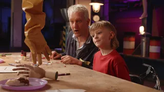 Presentator Maarten Bel kijkt naar creatie met kind