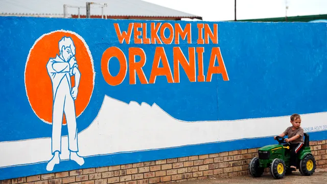 A young South African Afrikaner boy plays by a painted wall reading "Welcome in Orania" in Afrikaans on April 17, 2013 in Orania. 

Orania is a South Africa's only "purely" white town founded in the Northern Cape province in 1991 by Afrikaners, for Afrikaners opposed to the post-apartheid "rainbow nation", just after the release of Nelson Mandela. One thousand people live in Orania, and they try to be as self sufficient as possible. They have their own money, as well as their own flag. Orania's population grows at nine percent a year. It attracts Afrikaners who feel to be left out in the new South Africa, and who are scared of the country's high crime rates. The little town is protected by article 235 of South Africa's constitution, which guarantees the right of self determination. But residents here are thinking big - their next goal, the creation of an Afrikaner Republic.