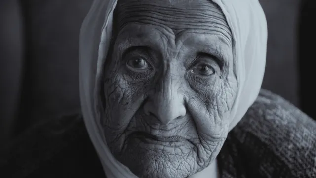 Oude vrouw kijkt in camera