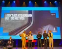 Op een toneel tijdens het Nederlands Film Festival ontvangt een witte man met halflang blond haar (Evan Frijters) een cheque van €5.000 voor zijn film I Didn't Get Into Berghain But I Did Meet Vica. Naast hem staat een gekleurde man in een lichtbeige pak die de prijs uitreikt. Rechts van hen staan drie mensen – een zwarte man in een zwart shirt, een zwarte man met bril en een witte persoon met krullen in een lichtbeige outfit. Links op het podium zit een muzikant met een gitaar. Op de achtergrond is een grote projectie van de winnende film te zien.