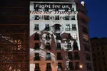 Projectie met de tekst ‘Fight for us, not for Trump’s billionaires’ op de gevel van de EU-Raadsgebouw in Brussel, 17 juni 2026. De actie richt zich tegen de invloed van Amerikaanse techbedrijven