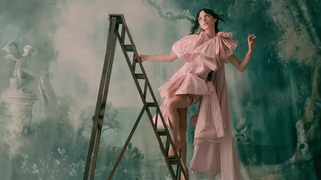 Vrouw in een roze jurk op een ladder