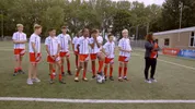 Een voetbalteam van jonge jongens staat op een voetbalveld
