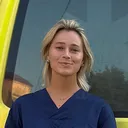 Frederiek Roukens staat in medische kleding voor een ambulance van Protect Ukraine.