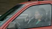 Nicolaas Veul en Noemi in een rode auto.