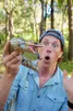 Freek heeft een dennenappelskink in zijn hand. Freek heeft een geshockeerde uitdrukking. De dennenappelskink heeft zijn bek open, zijn tong steekt uit.
