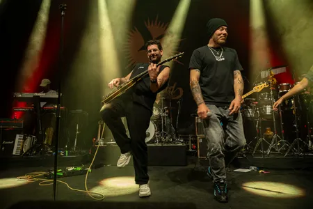 Foto van de zanger en de gitarist van Splendid, waarbij de gitarist zijn dansmoves laat zien