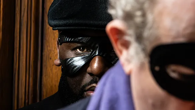 Bartofso staat met zijn masker op achter een man