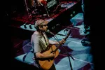 zanger Way Dynamic met een gitaar in zn hand voor de microfoon