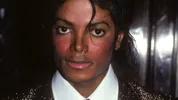 Michael Jackson is een man met zwart halflang haar en die de camera inkijkt