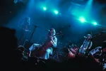 The New Eves, de frontvrouw zingt terwijl ze zittend de cello bespeeld