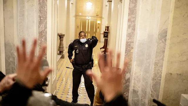 US Capitol Police (USCP) Officer Eugene Goodman confronts protesters as they storm the Capitol in Washington, D.C. after listening to a speech by President Trump on January 6, 2021. A large mob who convened on Washington, D.C. for a ?Save America? or ?Stop the Steal? rally was incited by President Trump and stormed the United States Capitol building, fighting with police, and damaging offices and rooms as they made their way through the building.

As President Trump openly condoned the violence, the D.C, mayor called for a 6 p.m. curfew, and mobilized the National Guard.