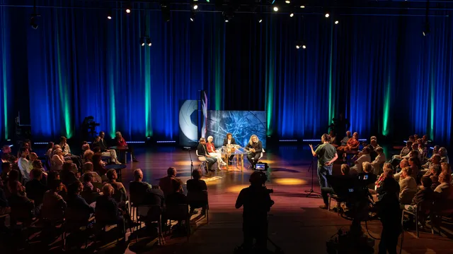 Foto van het publiek en gasten in het theater.