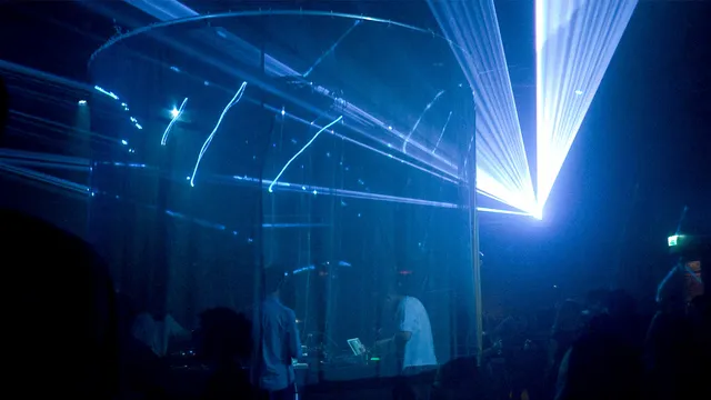Foto van het podium met lasers op de achtergrond.