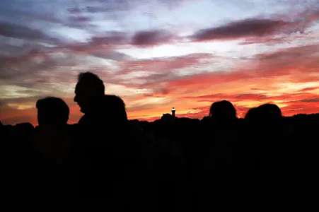 Westerlicht publiek met avondrood en vuurtoren