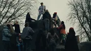 Een man op een rots omringt door andere mensen lager op de rots