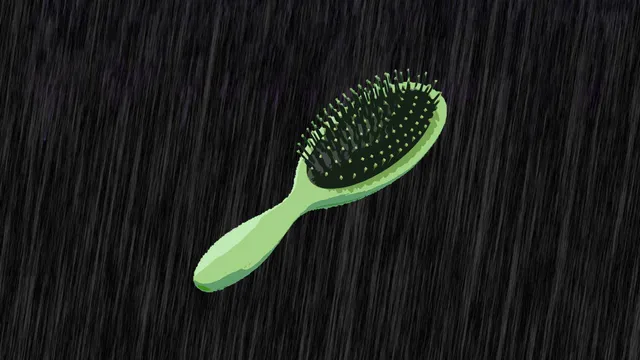 Een groene haarborstel op zwarte achtergrond met regendruppels