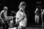 Foto van een man met een matrozenpet op zijn hoofd. Het is frontman van Fellatio met een microfoon in zijn hand.