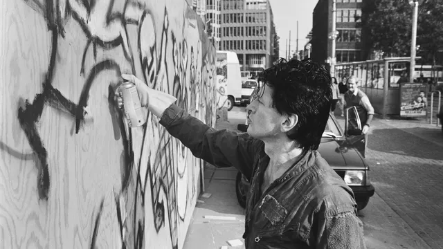 Herman Brood beschildert schutting op Rembrandtsplein in 1986
