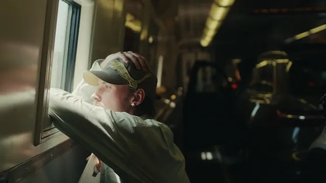 Joe zit in de trein en staart uit het raam