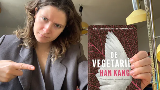 Hanneke houdt het boek 'De vegetariër' vast en wijst ernaar.