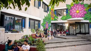 Mensen zitten buiten bij noodopvang voor vluchtelingen in Oss