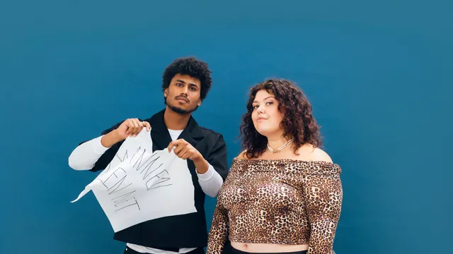 Yannick en Tatjana poseren voor een blauwe achtergrond. Yannick scheurt een groot vel papier met de tekst "DIKKE VETTE LEUGEN" en de vloer ligt vol verkreukeld papier. Tatjana draagt een panterprint top en lange zwarte rok. Beiden kijken serieus in de camera.