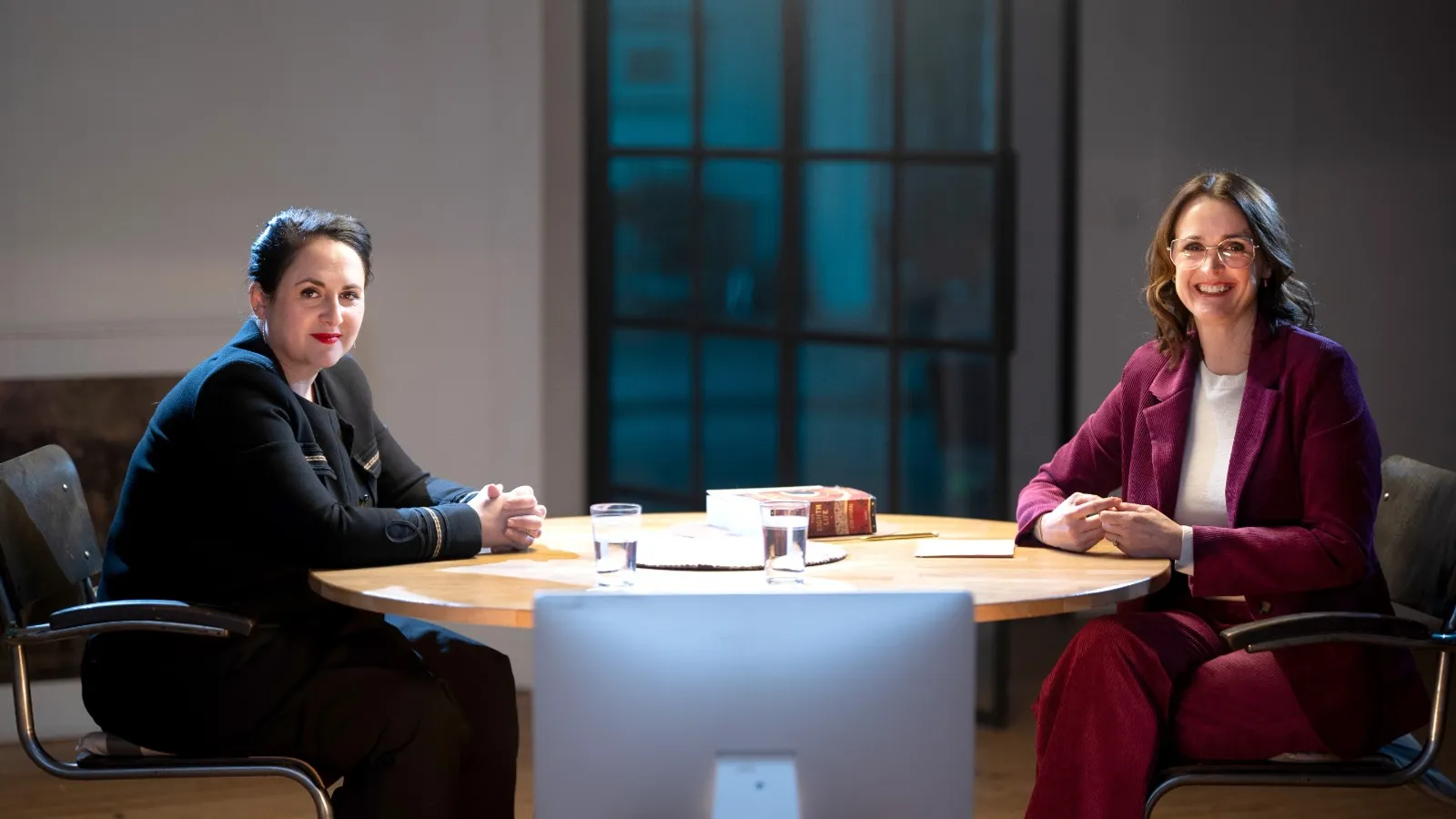 Janine Abbring en Nino Haratischwili zitten aan een tafel.