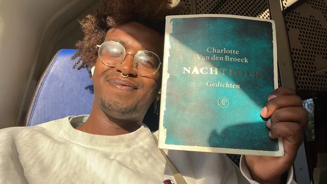Mahat houdt het boek 'Nachtroer' vast en poseert hiermee.